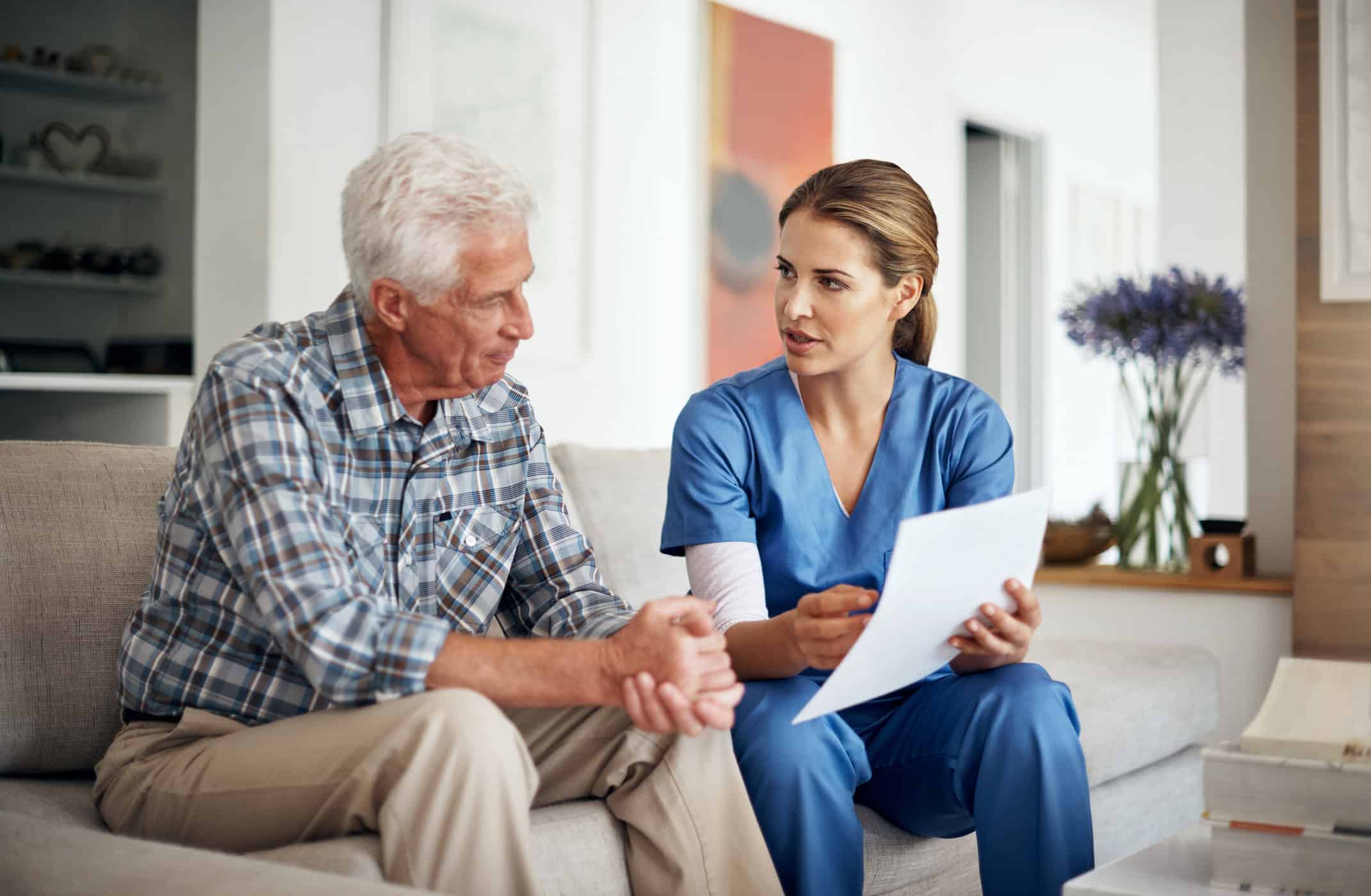 female doctor reviewing health records with male senior Medicare patient
